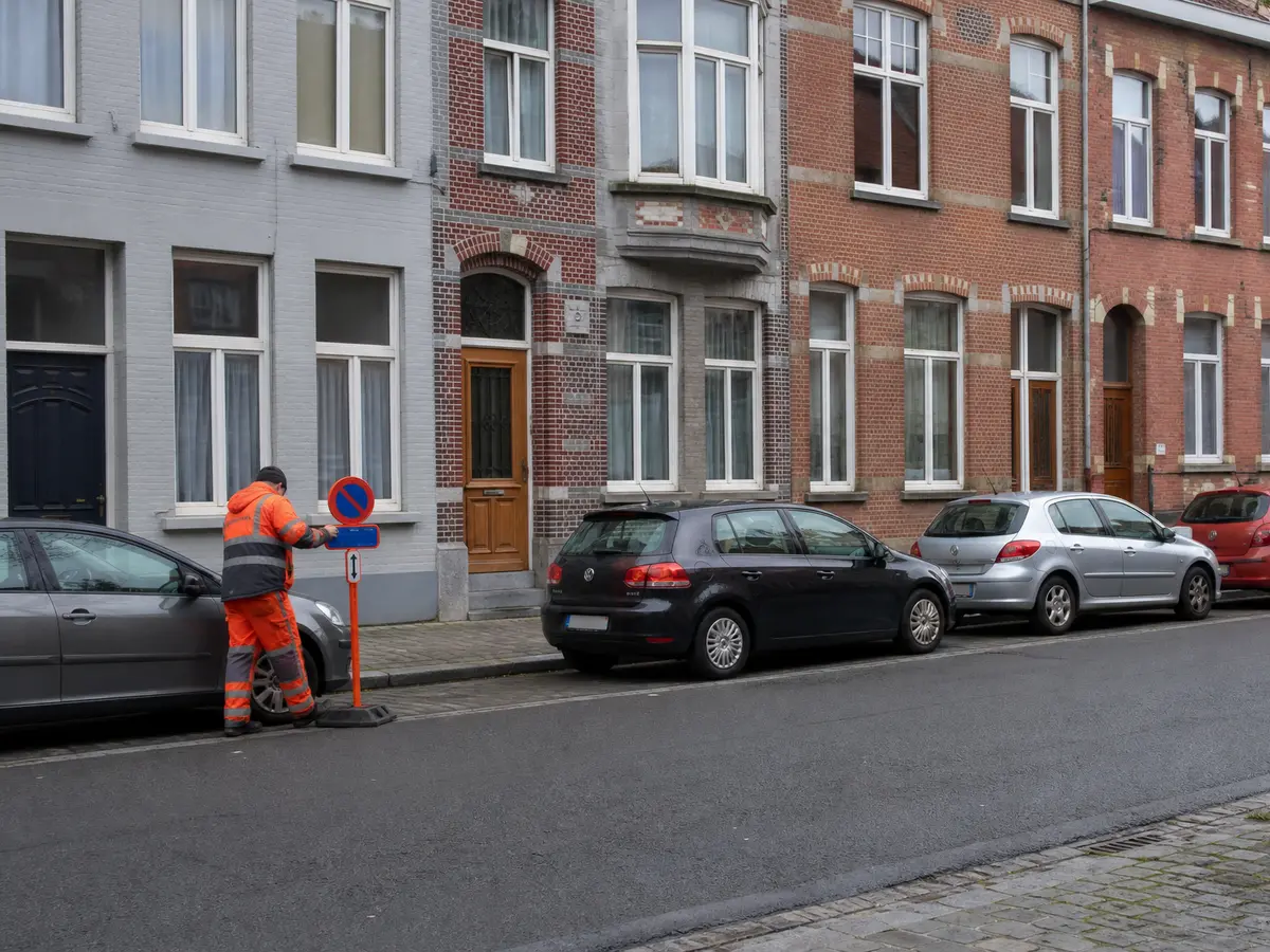 Twee medewerkers plaatsen parkeerverbodsborden in een Gentse straat